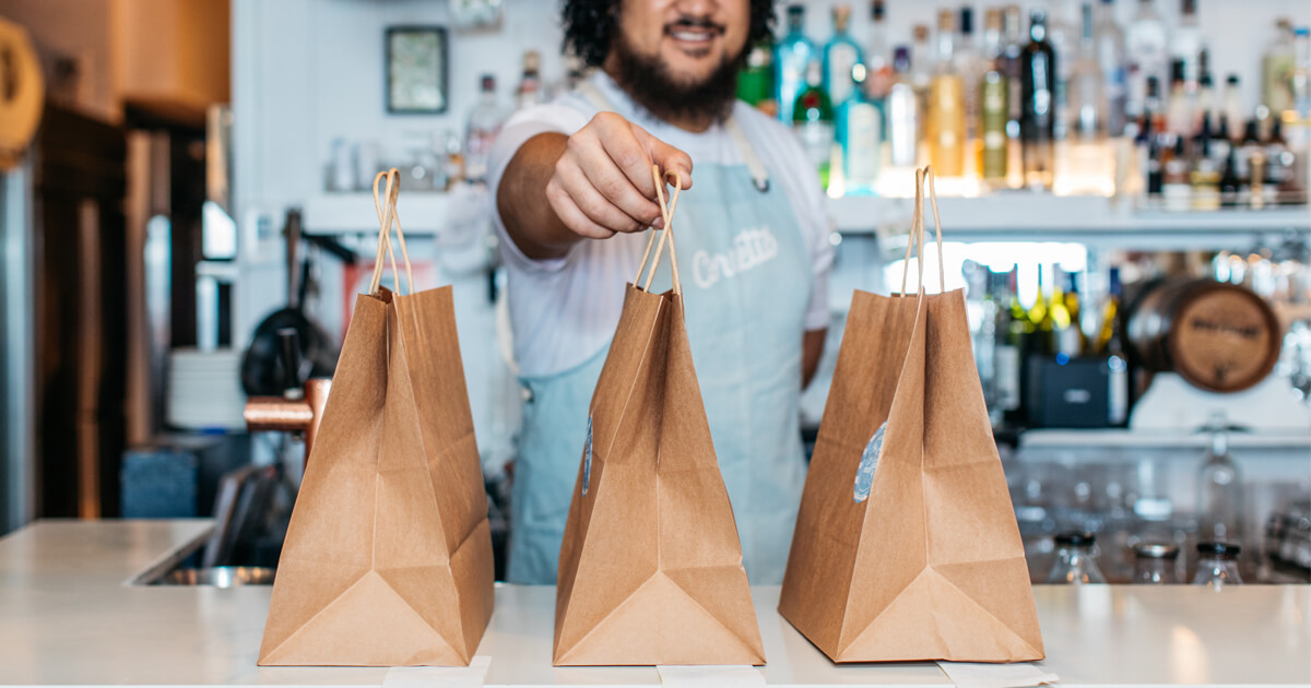 Cafe server with delivery bags on the counter